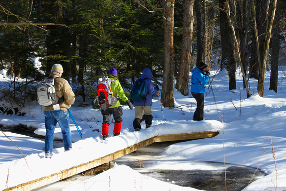 Winter Hikers Crossing Stream